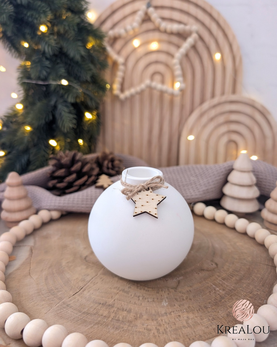 Weißer kugelförmiger Kerzenhalter aus Keramikgießmasse mit Juteband und Holzstern, dekoriert im warmen Winter-Scandi-Stil.