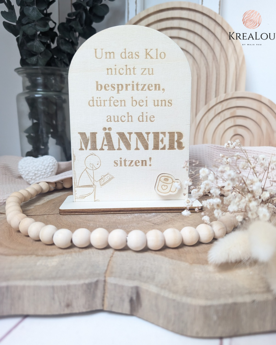 Lustiges WC-Schild aus hellem Pappelsperrholz mit Gravur: „Um das Klo nicht zu bespritzen, dürfen bei uns auch die Männer sitzen“, freistehend mit Standfuß