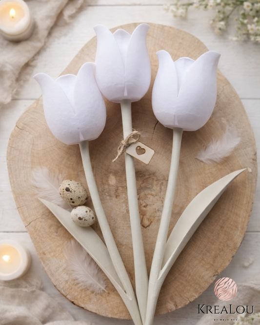 Drei weiße Dekotulpen aus PLA auf einer Holzscheibe dekoriert, mit hellen Blättern, Wachteleiern, Juteschnur und Herzanhänger – stilvolle Frühlingsdeko.