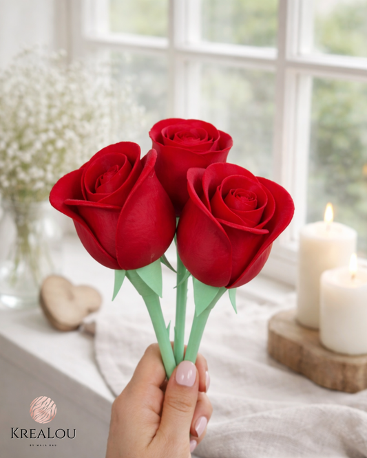 Drei rote Dekorosen aus PLA mit Dornen am Stiel, in einer Hand gehalten. Im Hintergrund Kerzen, Fensterlicht & Trockenblumen – liebevoll inszeniert.